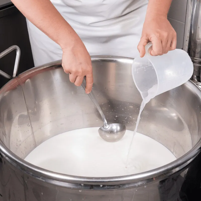 Melk in de pan, voordat het stremsel erbij gaat